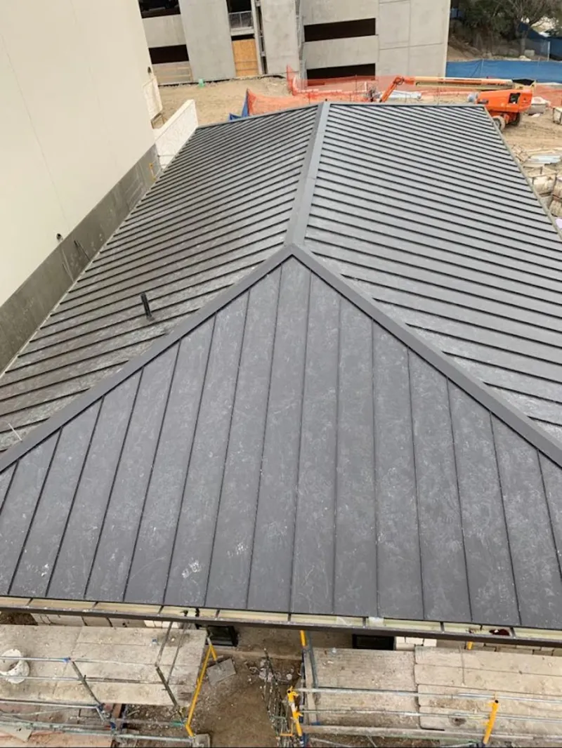 Commercial metal roof construction with crane equipment in Dunkirk